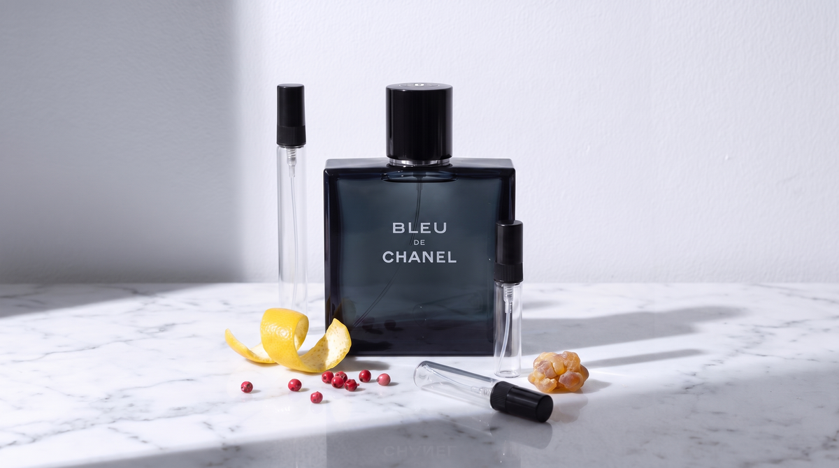 Decant de Bleu de Chanel sobre marmol blanco, junto a los atomizadores de 3, 5 y 10 ml