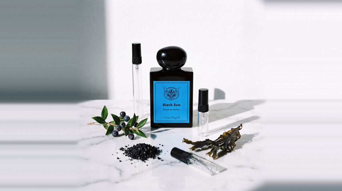 Decant de Lorenzo Pazzaglia Black Sea Extrait de Parfum sobre marmol blanco, junto a los atomizadores de 3, 5 y 10 ml