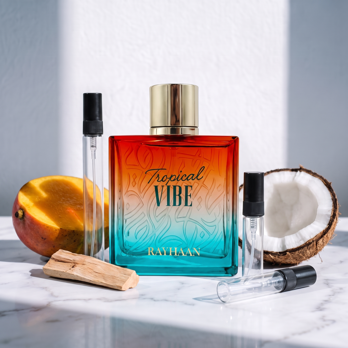 Decant de Rayhaan Tropical Vibe en 3, 5 y 10 ml junto a la botella degradada naranjo y turquesa original de Rayhaan