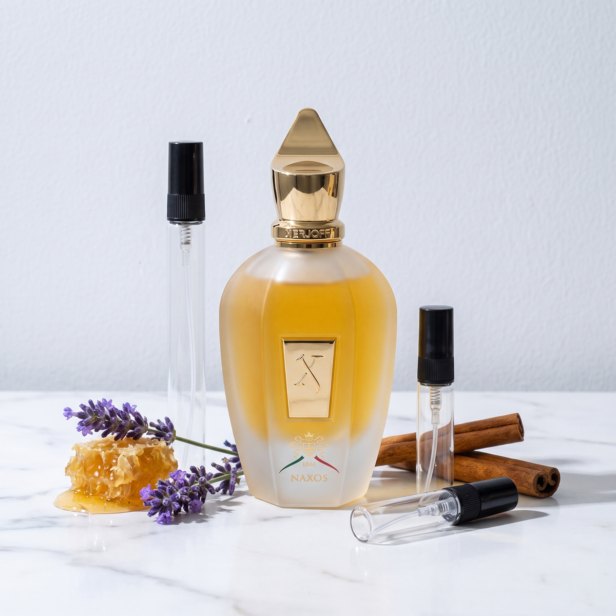 Decant de Xerjoff Naxos en 3, 5 y 10 ml junto a la botella esmerilada original de Xerjoff con lavanda, panal de miel y canela