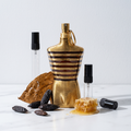 Decant de Jean Paul Gaultier Le Male Elixir en 3, 5 y 10 ml junto a la botella original dorada de Jean Paul Gaultier