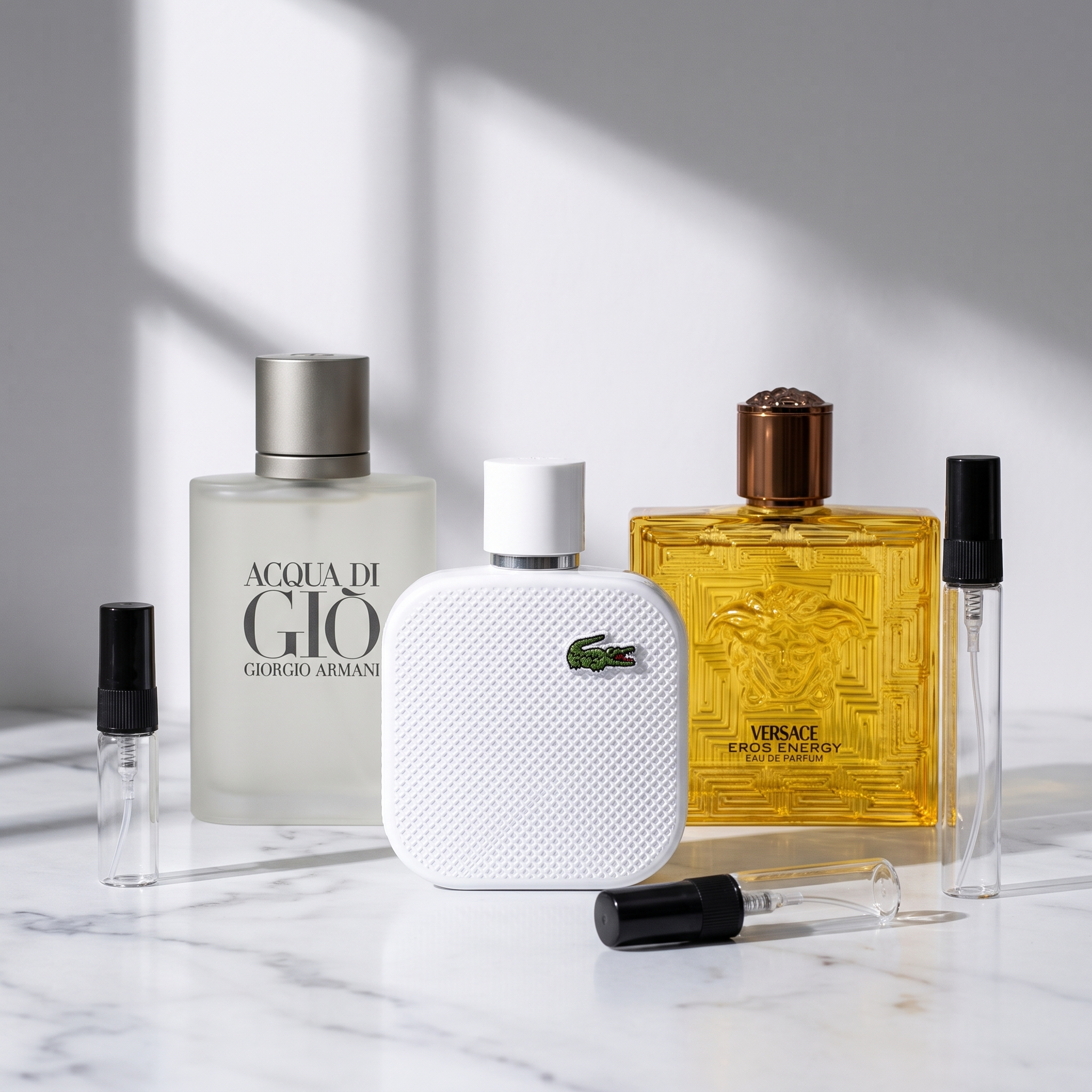 Pack Para el Verano: Acqua di Giò EDT, Lacoste L.12.12 Blanc y Versace Eros Energy sobre mármol, con los tres atomizadores de 3, 5 y 10 ml