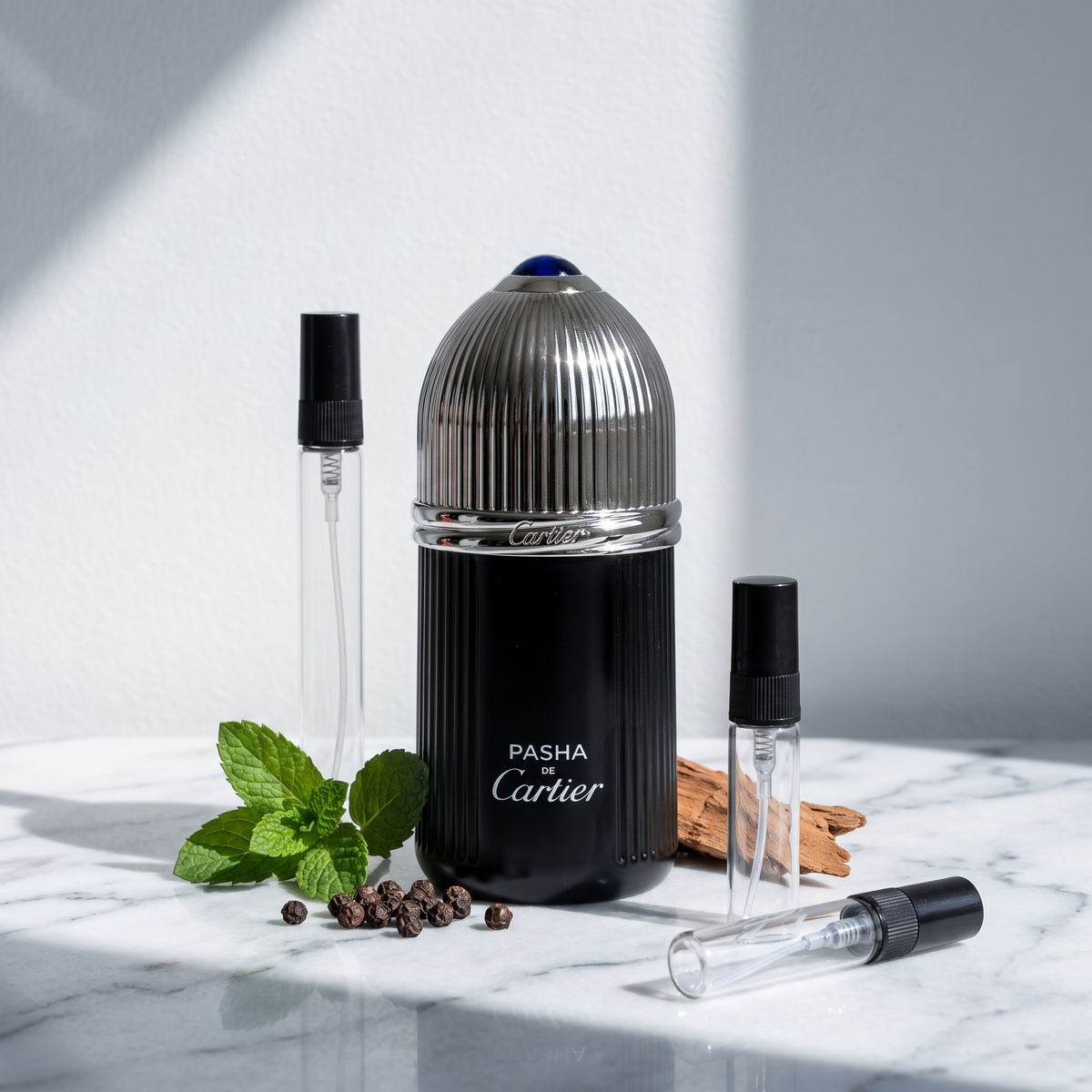 Decant de Pasha de Cartier Édition Noire junto a los tres atomizadores de vidrio de 3, 5 y 10 ml